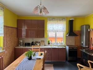 a kitchen with wooden cabinets and a wooden table at Põhk Greenhouse apartment in Viljandi +18 photos