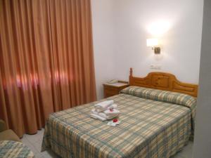 ein Hotelzimmer mit 2 Betten und Handtüchern auf dem Bett in der Unterkunft Hotel Paris in Lanjarón