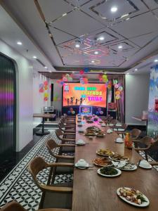a conference room with a long table and a large screen at Hồng Ngọc Hotel in Ðông Thôn