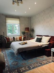 a bedroom with a large bed and a couch at Põhk Greenhouse apartment in Viljandi