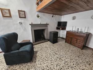 a living room with a chair and a fireplace at Dimora dei Consoli in Gubbio