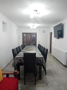 a dining room with a table and chairs and a television at Cabana Boema in Rausor