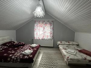 a bedroom with two beds and a chandelier at Cabana Boema in Rausor