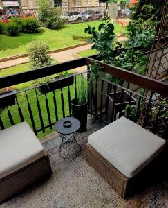 a balcony with two chairs and a stool and a table at Cozy Apartment between Sempione, City Life and MiCo ! in Milan