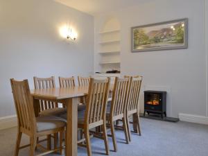 a dining room with a table and chairs and a fireplace at The Birches in Keswick
