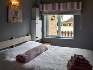 a bedroom with a bed with a towel on it at Oxley Cottage in Orby