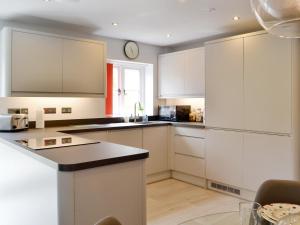 a kitchen with white cabinets and a counter top at The Old Chapel in Grosmont