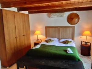 a bedroom with a large bed with green sheets at Alex's Guesthouse with a pool in Dhomátia