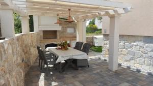 a patio with a table and chairs under a pergola at Apartments Rustic in Biograd na Moru
