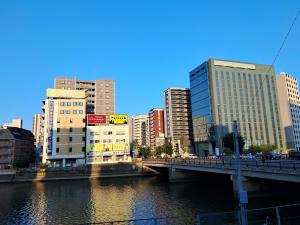 a bridge over a river in a city with buildings at Fukuoka Tabiji Hostel 福岡旅路ゲストハウス in Fukuoka