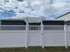a white fence in front of a house at Murray Lane Cozy Hideaway in Rockhampton