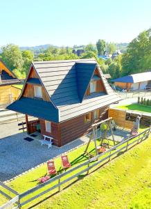 een klein huisje met een blauw dak en wat stoelen bij Podhalańska Chatka Zakopane in Zakopane