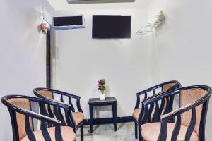 three chairs in a room with a tv and a table at Super Hotel O Qualia Hotel Dilsukhnagar Near Dilsukhnagar Metro Station in Hyderabad
