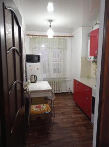 a kitchen with a table and a small table and a tableablish at Двухкомнатная квартира in Aktobe