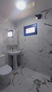 a white bathroom with a toilet and a sink at Stillwood Tsikhisdziri in Kobuleti +19 photos