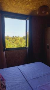 a bedroom with a bed and a large window at Stillwood Tsikhisdziri in Kobuleti