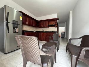 a kitchen with a table and chairs and a refrigerator at Apartamento Támesis Natural in Támesis +2 photos