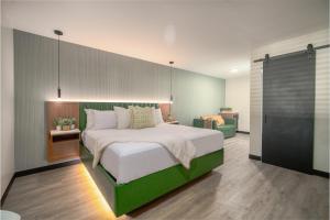 een slaapkamer met een groot bed met een groen hoofdeinde bij LYFE INN & SUITES by AGA- North Hollywood Near Universal Studios in North Hollywood