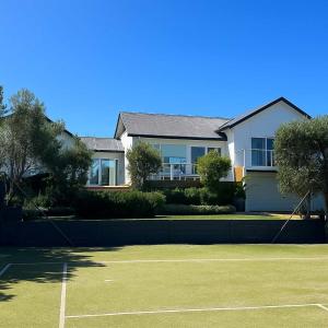 a tennis court in front of a house at Royadie Resort - Pool Spa Tennis 500m to beach in Blairgowrie