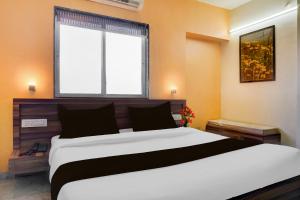 a bedroom with a large bed and a window at Townhouse Ambegaon Road Katraj Formerly White Castle in Pune
