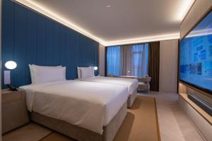 A bed or beds in a room at Shanghai Changfeng Business District Orange Crystal Hotel