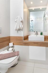 a bathroom with a white toilet and a sink at Notus Chania Crete in Chania Town