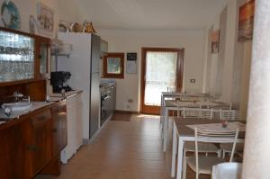 uma cozinha com uma mesa e cadeiras e um frigorífico em La Gemma em Roe