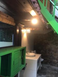 a bathroom with a sink and a green cabinet at Stairway To Heaven Bungalows and Restaurant in Amed