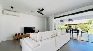 a living room with a white couch and a television at Un havre de paix in Calodyne