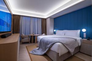 A bed or beds in a room at Shanghai Changfeng Business District Orange Crystal Hotel