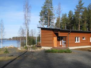 a small wooden cabin with a view of a lake at Jokiniemen Matkailu in Alapitkä