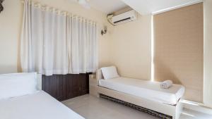 a small room with two beds and a window at Luxury 2BHK Apartment Near Candolim Beach in Candolim