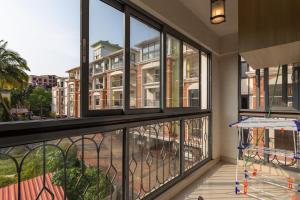 an apartment balcony with windows looking out onto a street at Luxury 2BHK Apartment Near Candolim Beach in Candolim