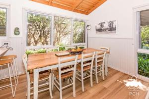 a dining room with a wooden table and chairs at Banksia Beauty in Sandy Point