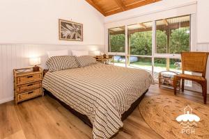 a bedroom with a bed and a large window at Banksia Beauty in Sandy Point