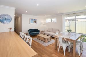 a living room with a table and a couch at Dunsborough Sunrise in Dunsborough