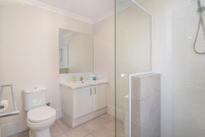a white bathroom with a toilet and a glass shower at Dunsborough Sunrise in Dunsborough +9 photos