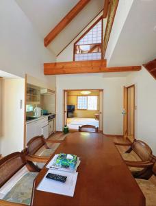 a room with a table with a keyboard and a kitchen at 軽井沢七福荘ホテル in Tsumagoi