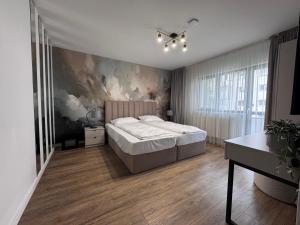 Un dormitorio con una cama y un cuadro en la pared. en AFI Apartments, en Suceava