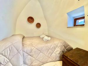 a bedroom with a bed with two towels on it at Trullo Sabotino in Alberobello