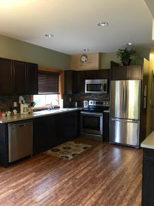 a kitchen with stainless steel appliances and wooden floors at Freedom Lodge & Spa in Madeira Park