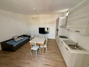 a small kitchen with a table and a couch in a room at Appartament Piras&Tascedda Barisardo 4 in Bari Sardo