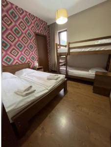 a bedroom with two bunk beds and a pink wall at Hill House in Stepantsminda