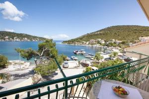 a bowl of fruit on a table on a balcony overlooking a harbor at Villa Stana in Vinišće