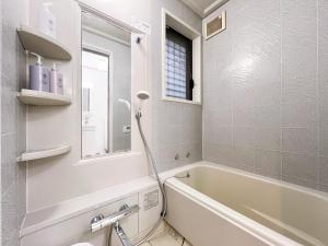 a white bathroom with a tub and a sink at nestay villa tokyo akasaka in Tokyo +35 photos