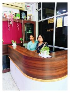 un hombre y una mujer sentados en un mostrador en Hotel Ravi B-R Group In Jaipur, en Jaipur