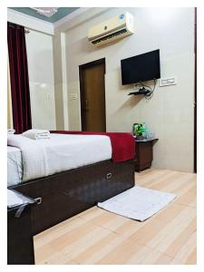 Un dormitorio con una cama y un televisor en la pared. en Hotel Ravi B-R Group In Jaipur, en Jaipur