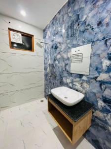 a bathroom with a sink and a blue and white wall at Hotel Pilgrim walking distance From Golden Temple in Amritsar