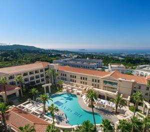 an aerial view of the resort with a pool and palm trees at The Siena PRIMO in Seogwipo