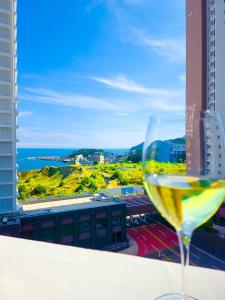 a glass of wine sitting on a ledge with a view at Vourne Osiria in Busan